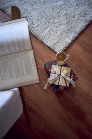                               ein Geschenkgutschein neben einem perfekten Ort zum Lesen und Entspannen, ein weißer Sessel umgeben von Büchern in einem hellen Raum         