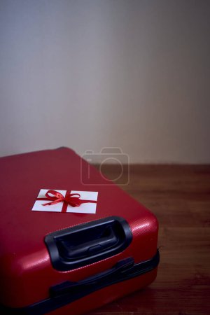 gift certificate in red and white colors on a red suitcase for travel