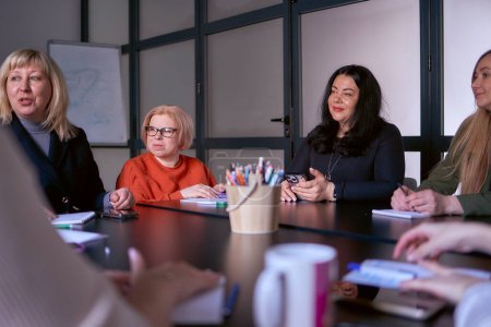 woman with disability listens attentively at a meeting in the office                    