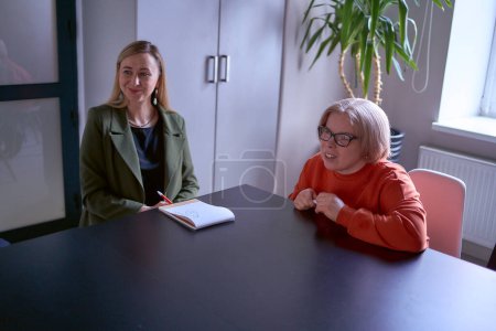  Frauen, einschließlich einer behinderten Person, besprechen bei einem Treffen im Büro die Strategie des Unternehmens                       