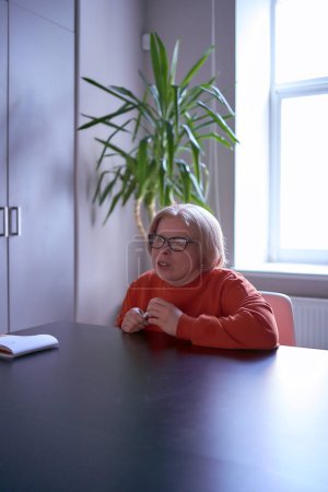 Frau mit Behinderung äußert ihre Meinung bei einem Treffen im Büro                         