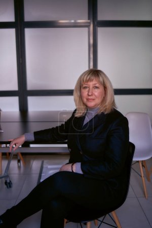 Téléchargez les photos : Portrait d'une femme blonde d'âge moyen en costume d'affaires au bureau - en image libre de droit