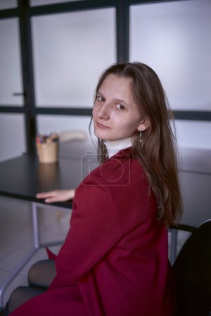           portrait of a young woman in a red office suit                     