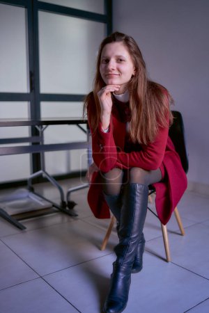           Porträt einer jungen Frau im roten Büroanzug                     
