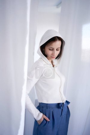 a  young teenage girl fighting brain cancer in a studio photo shoot, white curtains surround the girl, purity, innocence, minimalism            