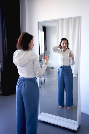 una joven adolescente luchando contra el cáncer cerebral mira su reflejo en el espejo