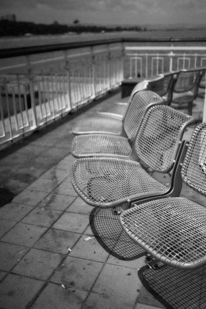 Foto de Fila de sillas de metal en el muelle - Imagen libre de derechos