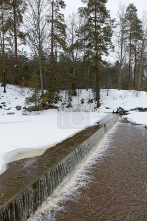 Foto de Vista de la pequeña cascada en el río Mustijoki en invierno con nieve en el suelo, Lahankoski, Pornainen, Finlandia. - Imagen libre de derechos