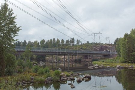 Blick auf die Autobahnbrücke Ahvenkoski über Stromschnellen am Kymijoki-Fluss bei bewölktem Sommerwetter, Pyht, Finnland.