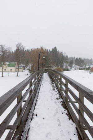 Photo for Old wooden bridge over Mustijoki river in cloudy winter weather, Laukkoski, Pornainen, Finland. - Royalty Free Image