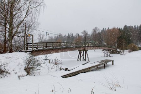 Foto de Puente de madera viejo sobre el río Mustijoki en clima nublado de invierno, Laukkoski, Pornainen, Finlandia. - Imagen libre de derechos