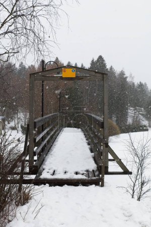 Foto de Puente de madera viejo sobre el río Mustijoki en clima nublado de invierno, Laukkoski, Pornainen, Finlandia. - Imagen libre de derechos