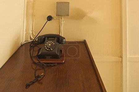 Photo for Old rotary telephone on wooden desk on a vintage steamship. - Royalty Free Image