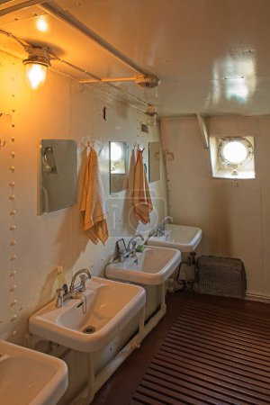 Téléchargez les photos : Salle de bain avec lavabos, miroirs et serviettes sur un bateau à vapeur vintage. - en image libre de droit