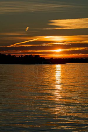 Sunset with clouds in the sky in autumn at seashore on the island of Torra Lv, Espoo, Finland.