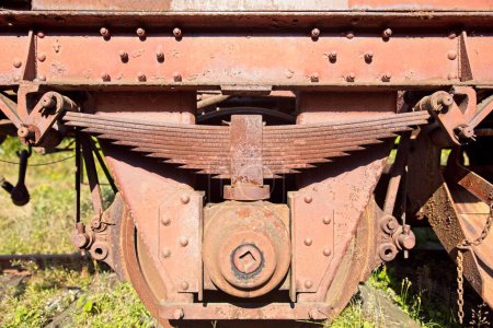 Closeup of old rusted metal leaf springs on a freight train boxcar.