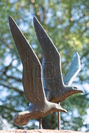 Statue en métal de deux mouettes volant.