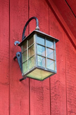 Lámpara exterior en una puerta de madera.