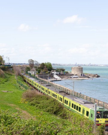Tren en una ruta de sceninc alrededor de la playa de Seapoint en Irlanda junto al mar