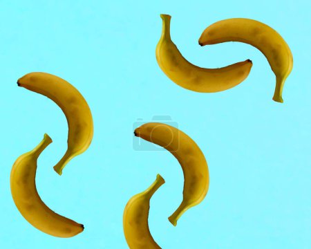 Isolated bananas on a light blue background. Copy space. Flat lay. Minimal fruit concept. Creative pattern.