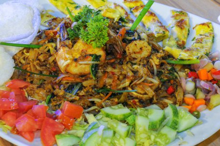 Photo for Fried kwetiaw with fried prawns, served with sliced omelet and pickles - Royalty Free Image