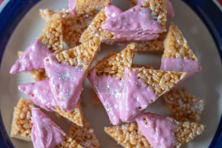Téléchargez les photos : Cerise de couleur licorne rose avec des paillettes d'argent comestibles sur des gâteaux à bulles de riz au miel prêts comme cadeau d'anniversaire parfait! - en image libre de droit