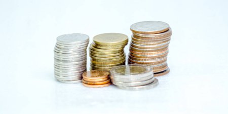 Many Thai baht coins arranged in neat layers on a white background, isolate