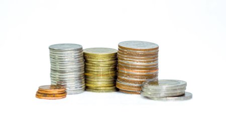 Many Thai baht coins arranged in neat layers on a white background, isolate