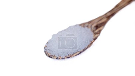 Close-up shot of table salt mixed with white iodine in a wooden spoon. It's for seasoning food. White background. Isolated.