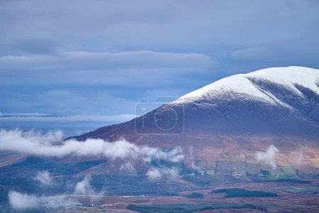 Snow on Nephin mountain dramatic sky low clouds Ireland. High-quality photo