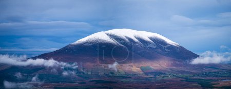 Snow on Nephin mountain dramatic sky low clouds Ireland. High-quality photo