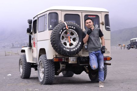 Téléchargez les photos : Asiatique homme avec noir voiture dans l désert - en image libre de droit