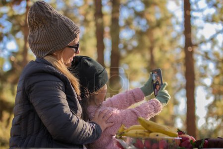 Mutter und Tochter beim Selfie am Muttertag Familie erinnert sich an gesundes Essen und Obst bei Sonnenuntergang im Wald
