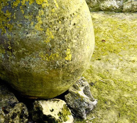 Foto de Vieja jarra con piedras y líquenes a su alrededor. - Imagen libre de derechos