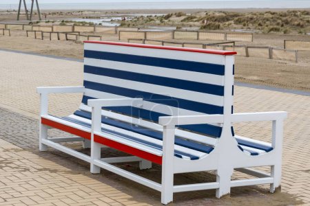 old blue and white wooden bench on the beach promenade