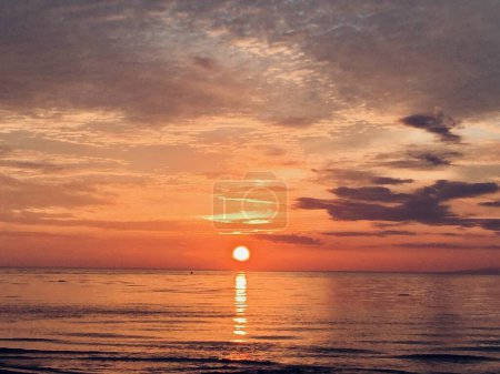 Téléchargez les photos : Enchanté par le soleil couchant dans la mer et les couleurs enchanteresses du crépuscule au port de Bemu, côte sud-est de l'île de Seram, Indonésie. - en image libre de droit