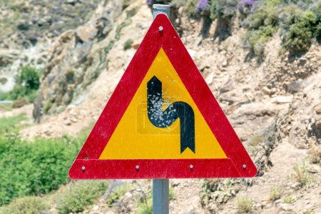 Una señal de trafic a un lado una carretera con rastros de balas en medio en la isla de Creta (Grecia)