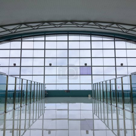 Téléchargez les photos : Jakarta 31 déc 2022 : Grande fenêtre vitrée au Terminal 3 Aéroport international Soekarno Hatta Portes de départ face à la piste. toit incurvé avec structure en acier de cadre d'espace, garde-corps de barrière en verre - en image libre de droit