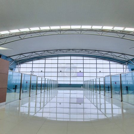 Foto de Yakarta Dic 31 2022: Enorme ventana de cristal en la Terminal 3 Aeropuerto Internacional Soekarno Hatta Puertas de salida frente a la pista. techo curvo con estructura de acero de marco espacial, barandilla de barrera de vidrio - Imagen libre de derechos