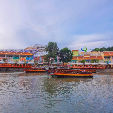 Photo for Singapore - January 01 2023: Clarke Quay at Sunset, view of Cruise Riverboats berthed and passing along the Singapore River with colorful traditional Chinese Peranakan shophouses at the background - Royalty Free Image