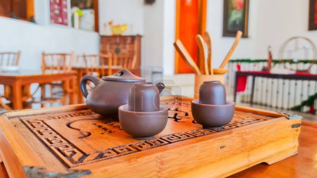 Foto de Yakarta Indonesia Dec 10 2023: Tetera china, tazas y bandeja de madera y cubiertos utilizados en la ceremonia tradicional del té chino en una mesa en una casa de té o restaurante - Imagen libre de derechos