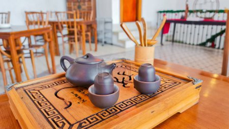 Foto de Yakarta Indonesia Dec 10 2023: Tetera china, tazas y bandeja de madera y cubiertos utilizados en la ceremonia tradicional del té chino en una mesa en una casa de té o restaurante - Imagen libre de derechos