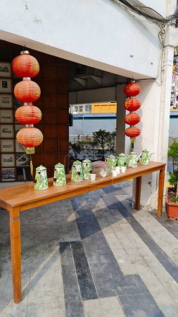 Foto de Yakarta Indonesia Dec 10 2023: Puesto de té al lado de una carretera. Teteras de cerámica de China jarras en una larga mesa de madera con linternas chinas. estilo de vida peranakan - Imagen libre de derechos