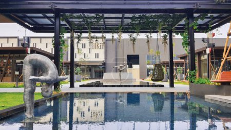 Téléchargez les photos : Jakarta 01 Nov 2023 : prise de vue frontale d'un étang réfléchissant bleu avec une sculpture en acier et une verrière en acier. Indonésie Design District PIK2 - en image libre de droit