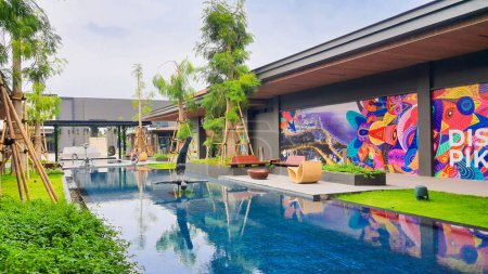 Téléchargez les photos : Jakarta Nov 01 2023 : belle piscine bleue azur avec un beau paysage tropical et une couverture de marketing de thésaurisation murale colorée en Indonésie Design District PIK2 - en image libre de droit