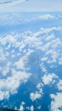 Wing of an airplane with a blue tip with beautiful blue sky and white cloud as background