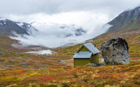 Téléchargez les photos : Petite cabane en montagne avec brouillard en arrière-plan - en image libre de droit