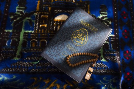 Gebetsperlen aus Holz, die auf dem Koran liegen