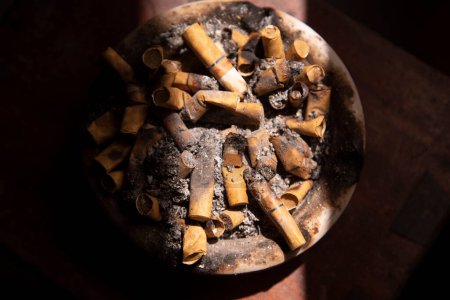 Photo for Top View dirty ashtray full of cigarette butts with contrast light - Royalty Free Image