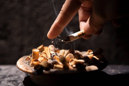 Photo for Throwing cigarette ash with a finger on the ashtray - Royalty Free Image